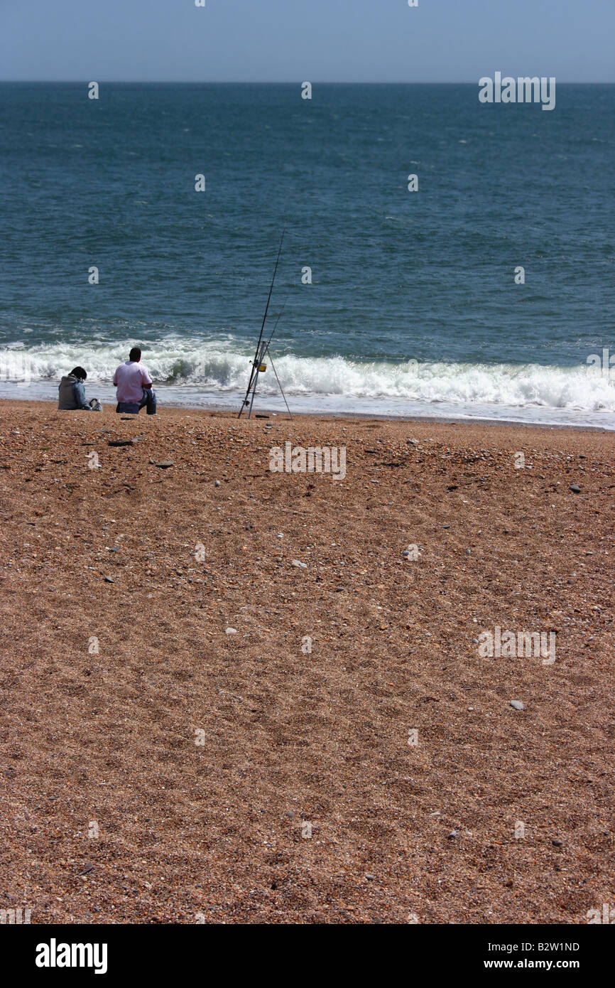 Accoppiare la pesca sulla spiaggia di ciottoli a Slapton Sands, Devon, Inghilterra Foto Stock