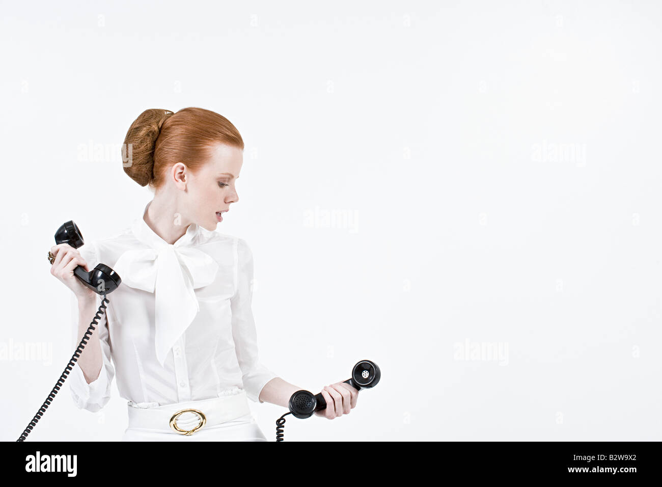 Una imprenditrice tenendo i ricevitori del telefono Foto Stock