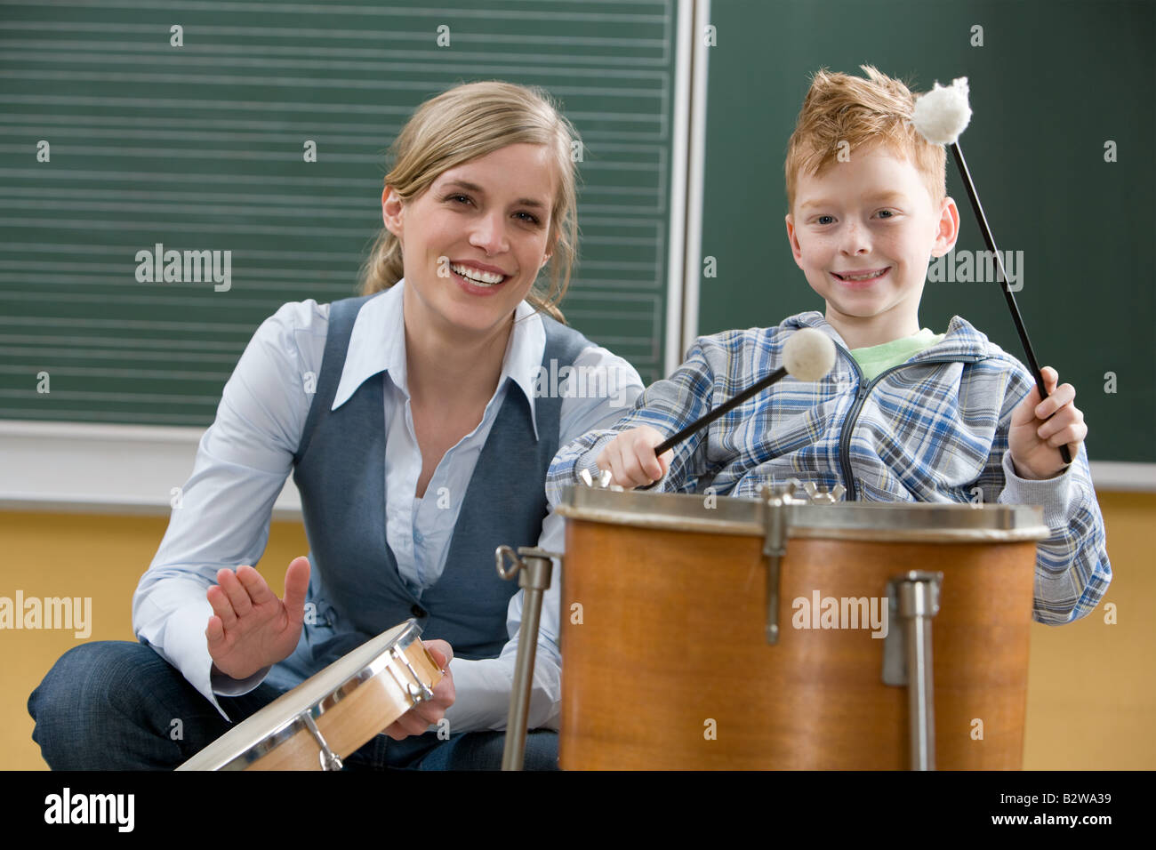 Insegnante e ragazzo suonare il tamburo Foto Stock