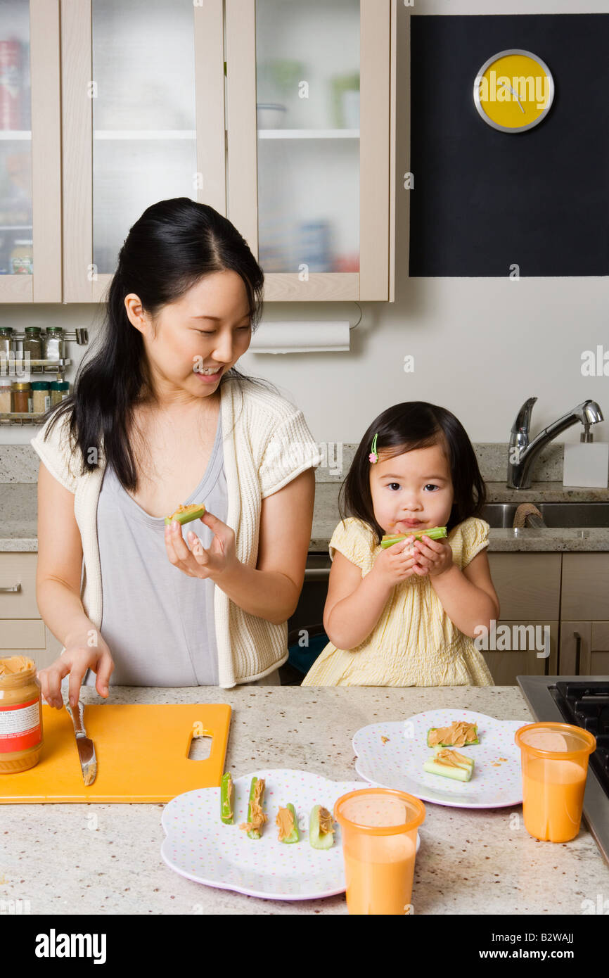 Una figlia aiutando la madre in cucina Foto Stock