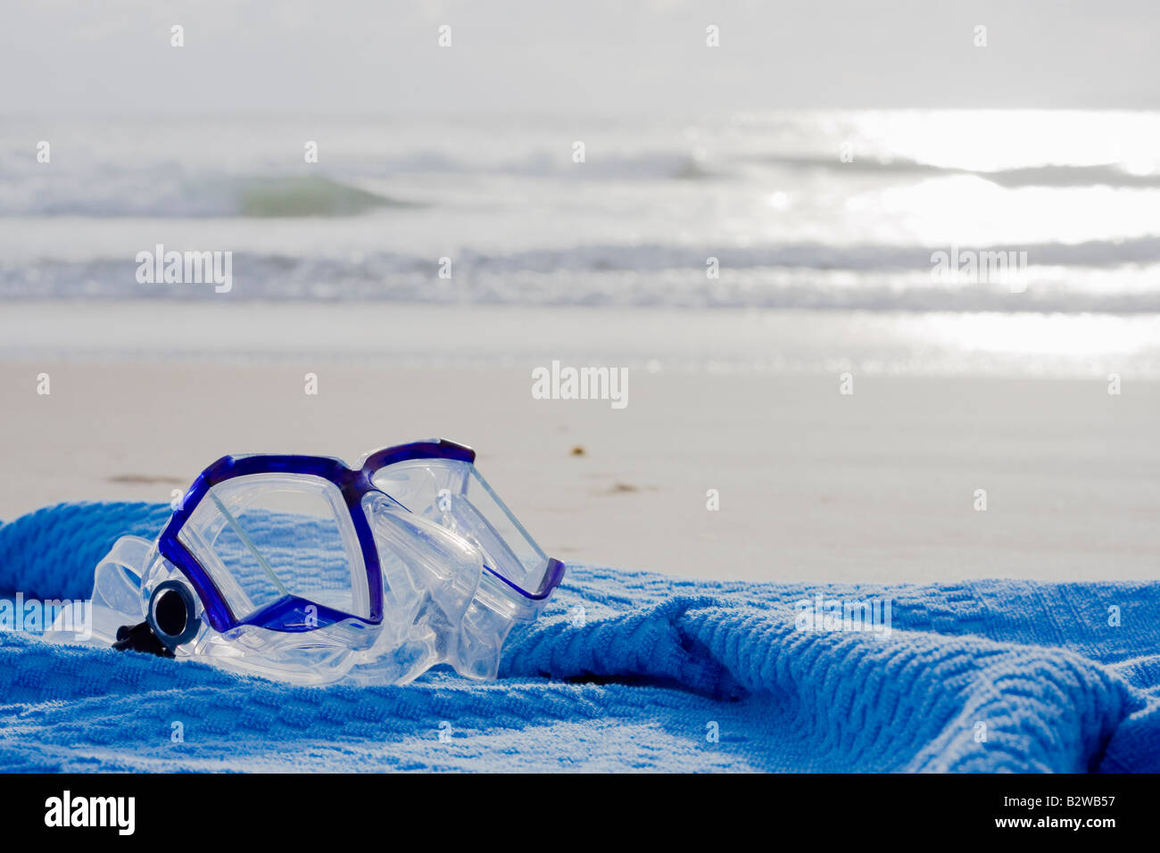 Maschera subacquea su un asciugamano blu sulla spiaggia Foto Stock