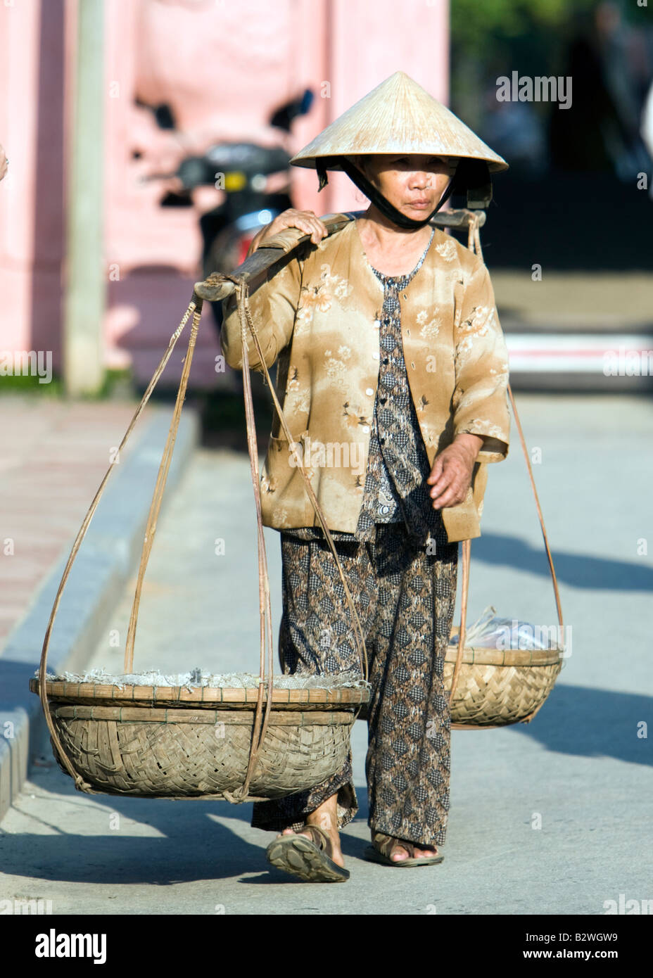 Cappello conico donna con carbone nel cestello di spalla landmark ponte  coperto giapponese Hoi An Vietnam Foto stock - Alamy