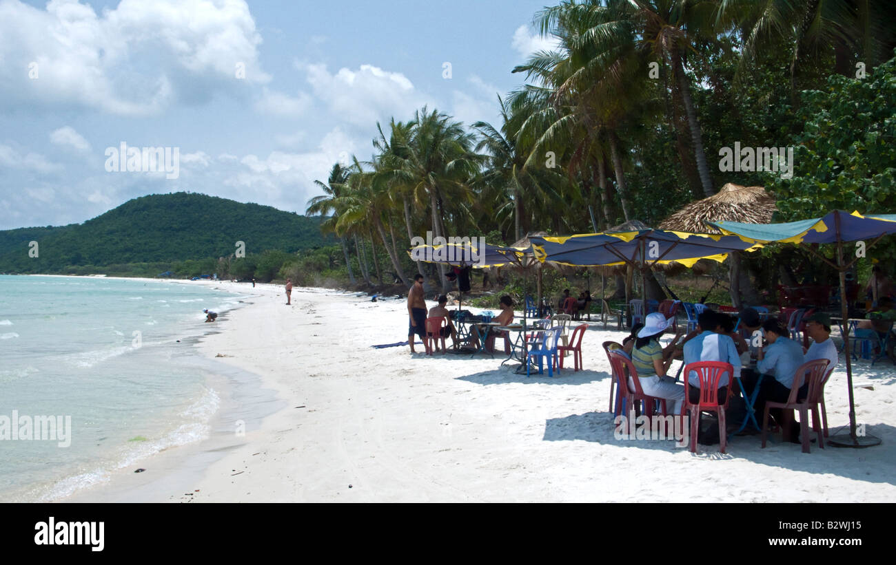 I visitatori di mangiare e bere in ombra di ombrelloni sabbia bianca Bai Sao beach south east Phu Quoc Island in Vietnam Foto Stock