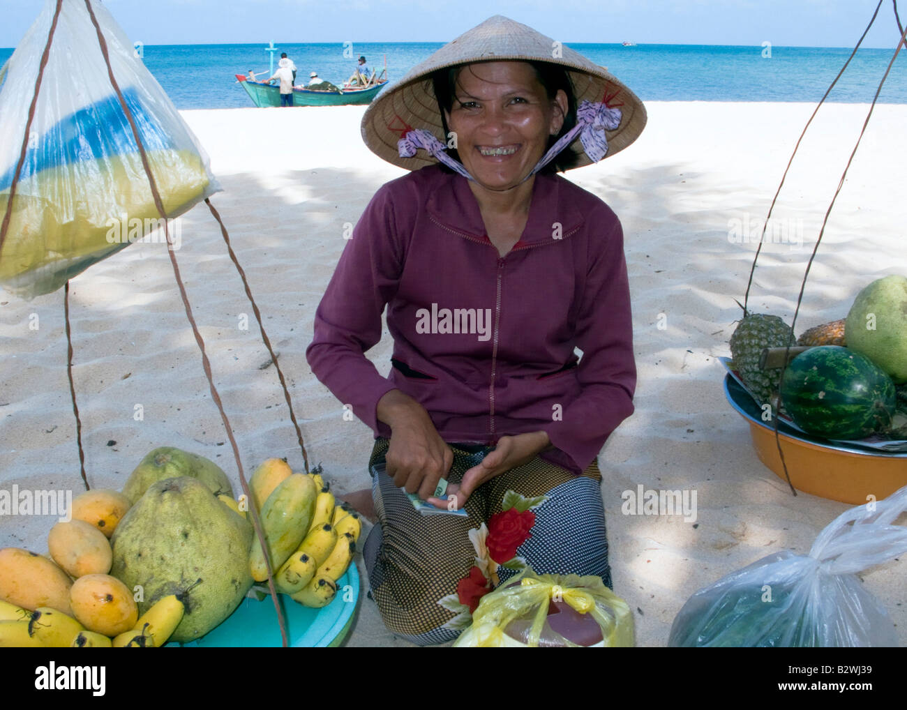 Cappello conico donna frutta tropicali venditore Long Beach Phu Quoc Island  in Vietnam Foto stock - Alamy