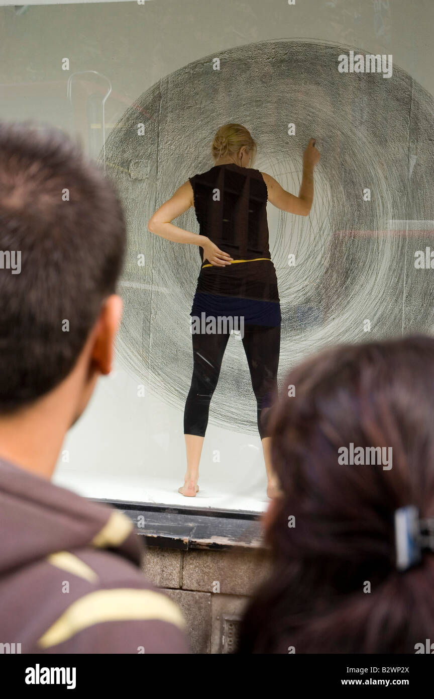 Artista esegue la sua opera in una finestra al Central Saint Martin's su Charing Cross Road, Londra Foto Stock