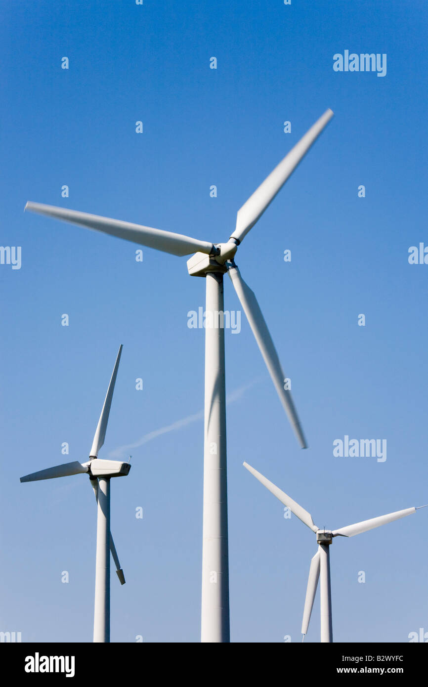 Tre turbine eoliche generatori di energia elettrica sostenibili per energia alternativa nel primo piano della centrale eolica contro il cielo blu. Galles del Nord Regno Unito Gran Bretagna Foto Stock