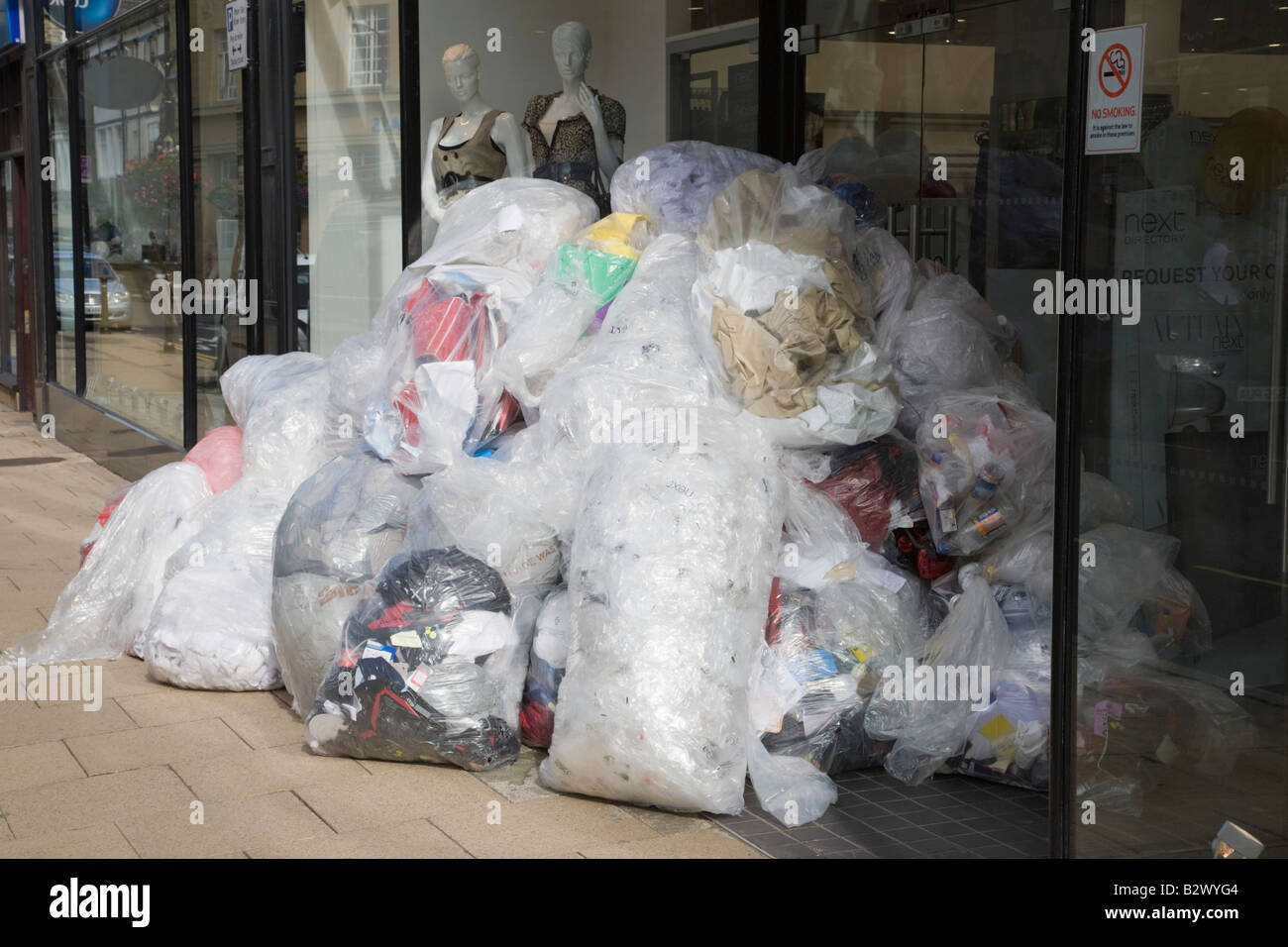 Grande pila di sacchi di plastica per il riciclaggio al di fuori di un negozio in Inghilterra La Gran Bretagna REGNO UNITO Foto Stock