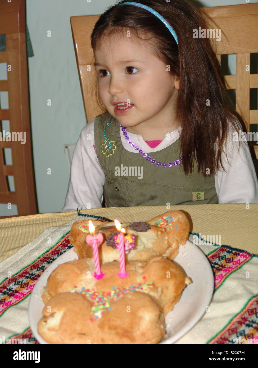 Una piccola ragazza con una torta di compleanno Foto Stock