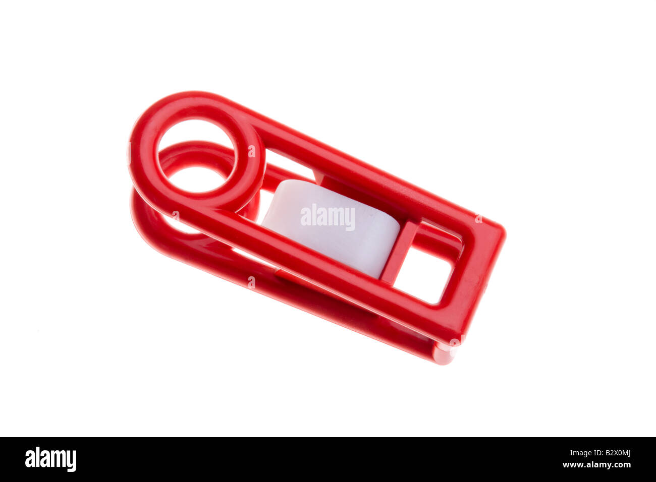 Un rosso in plastica clip a molla utilizzata per il trattenimento di fogli insieme. Foto Stock