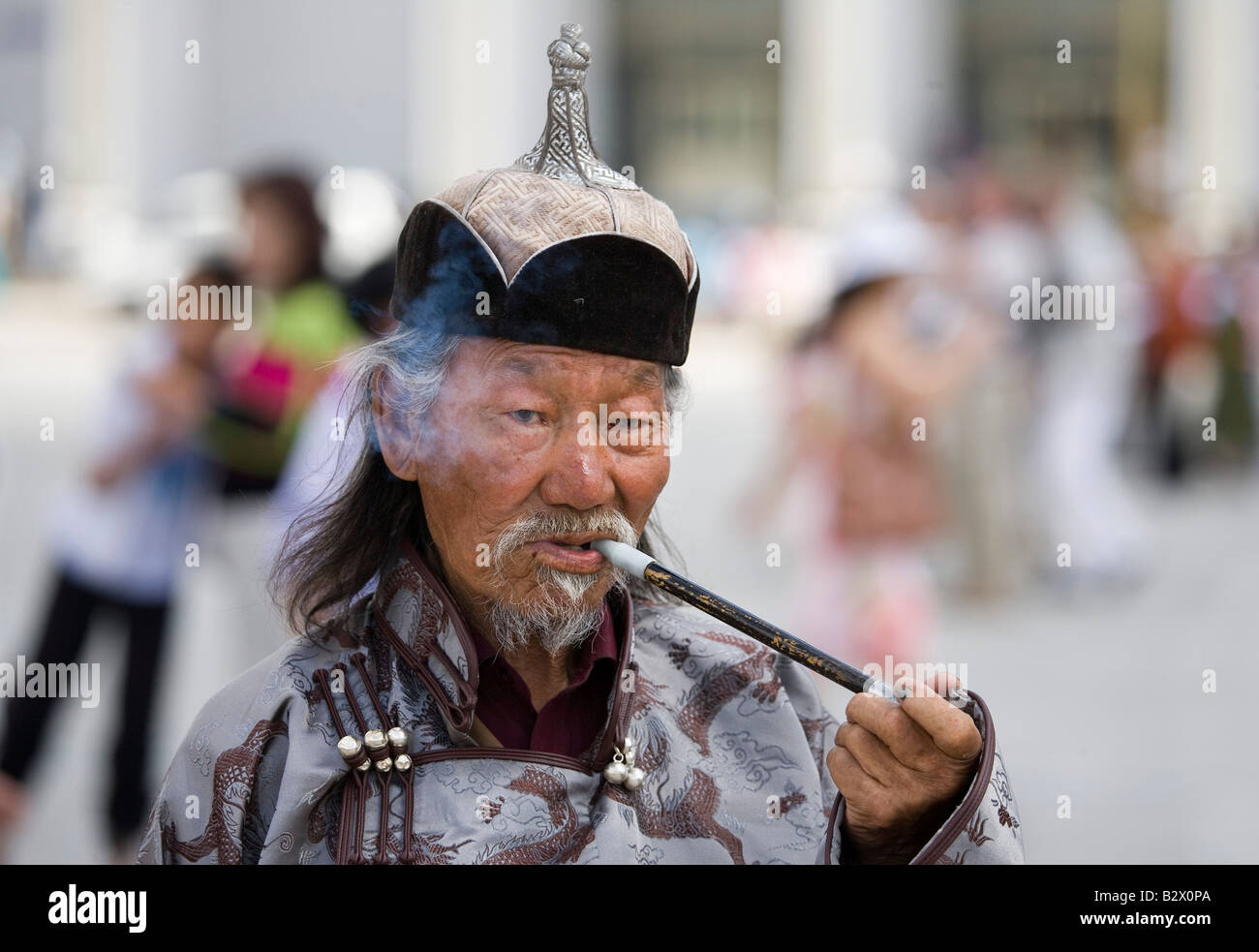 Sukhbaatar Square nel centro di Ulaanbaatar vecchio uomo fumatori tubazione di oppio Foto Stock