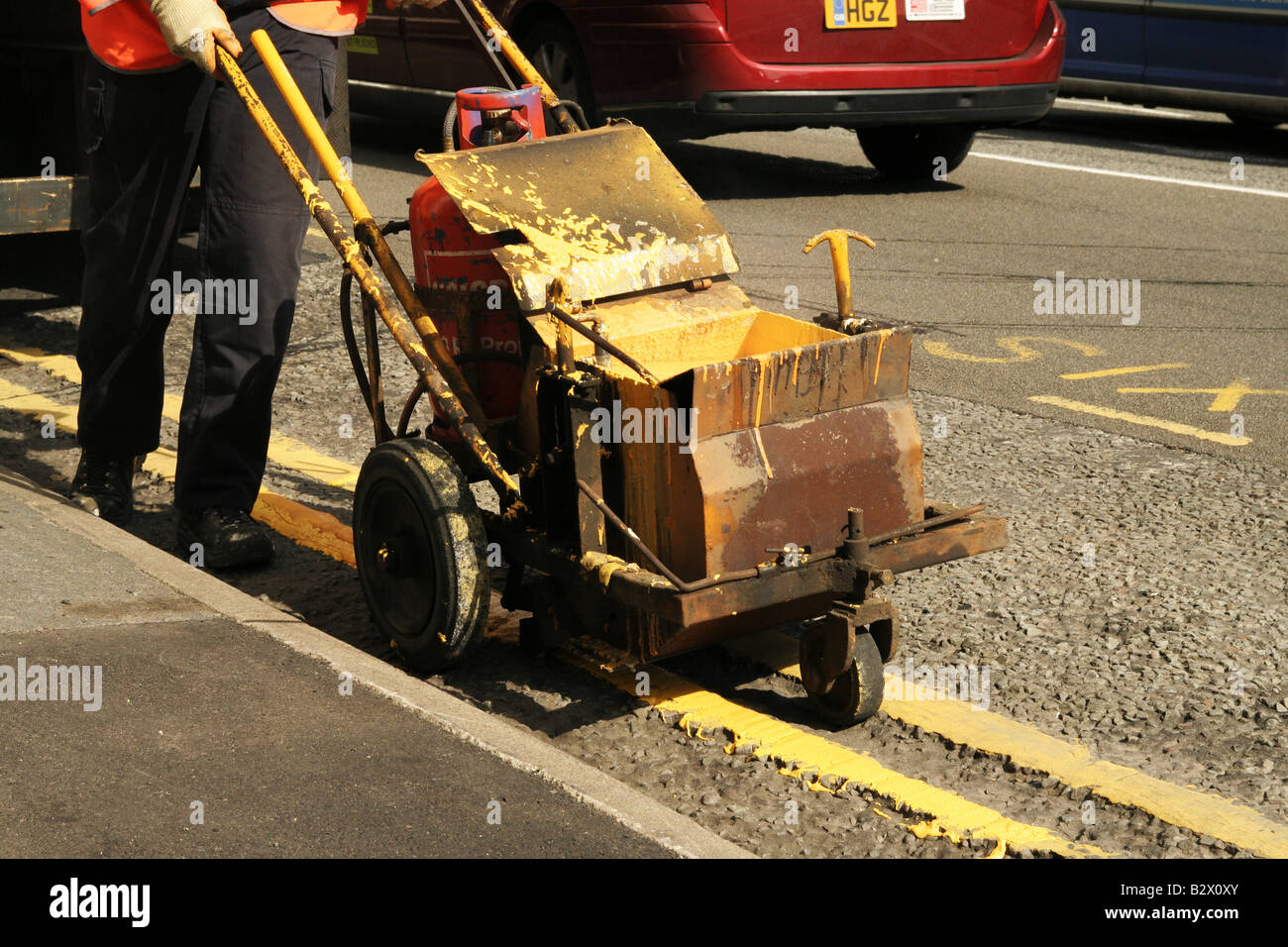 Segnaletica stradale, banda stradale, ingegneria, salute e sicurezza, verniciatura stradale, Uomini al lavoro, vernice trolly, linea di marcatura PRAM, linea di marciapiede successiva, segno giallo Foto Stock