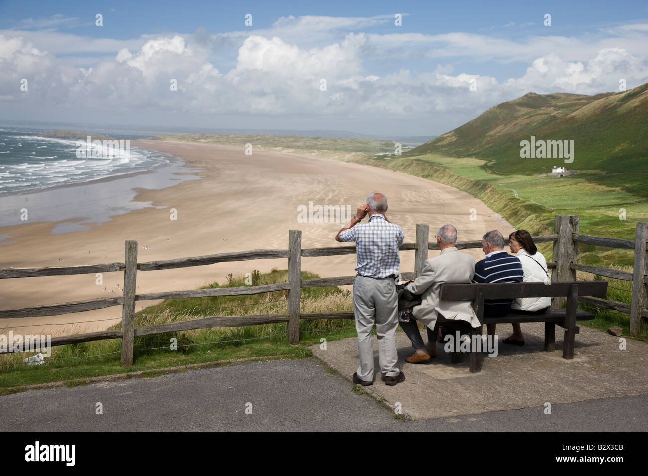 I visitatori di prendere in vista della spiaggia di Rhossili Bay in Gower Galles Foto Stock