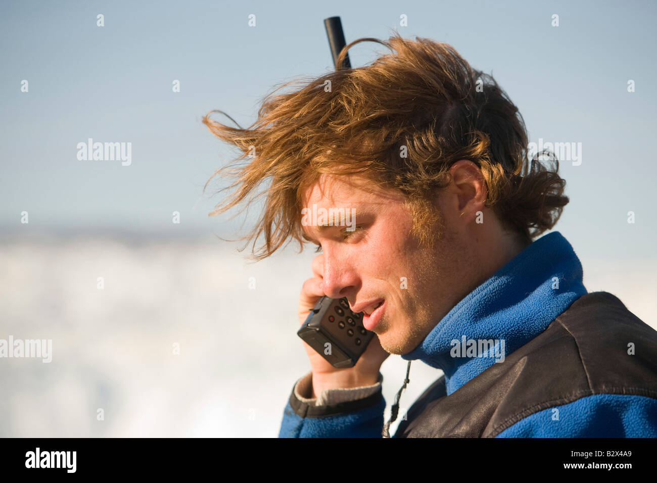 Un tour della Groenlandia guida utilizzando un telefono satellitare in una zona remota a Camp Victor su Greenlands west coast Foto Stock
