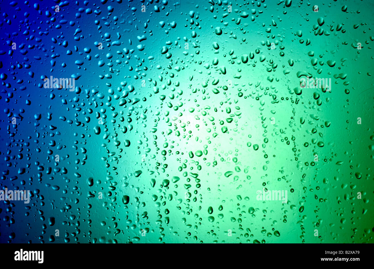 Luci al neon brillare attraverso una pioggia caduta finestra coperto Foto Stock