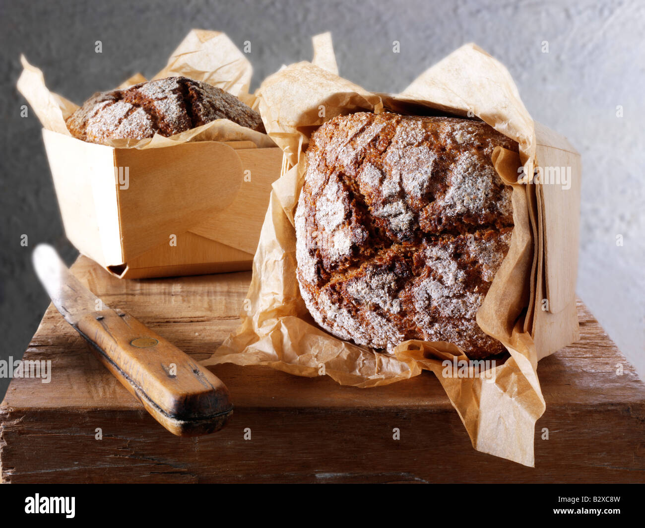 Pani di pane di Rye artigianale in un ambiente rustico su un tavolo di legno Foto Stock