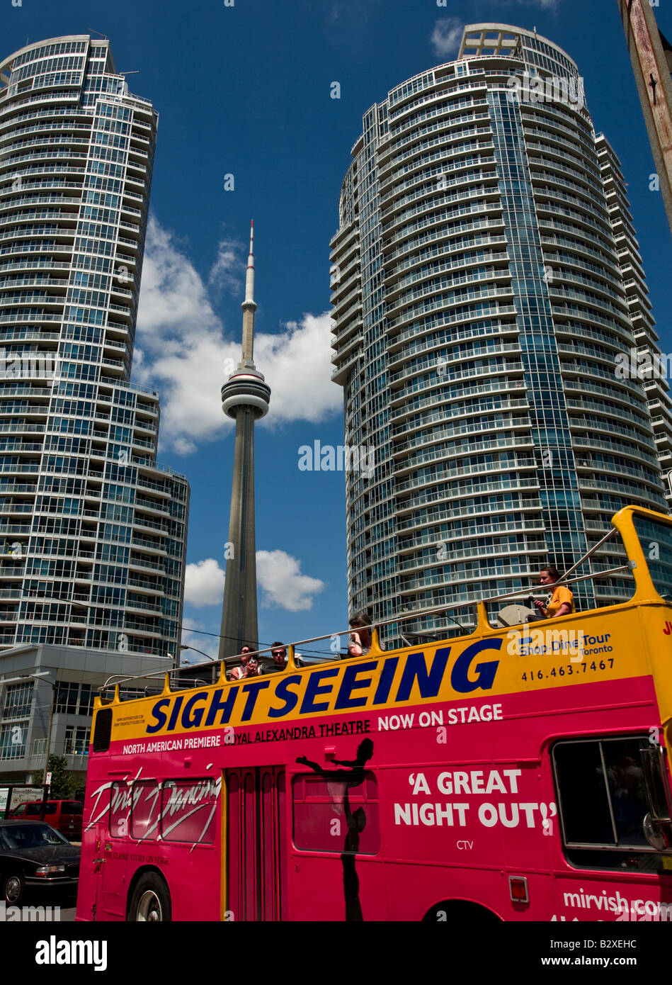 Alto edificio di appartamenti, sightseeing bus e la CN Tower vista dal porto di Toronto, Ontario, Canada. Foto Stock