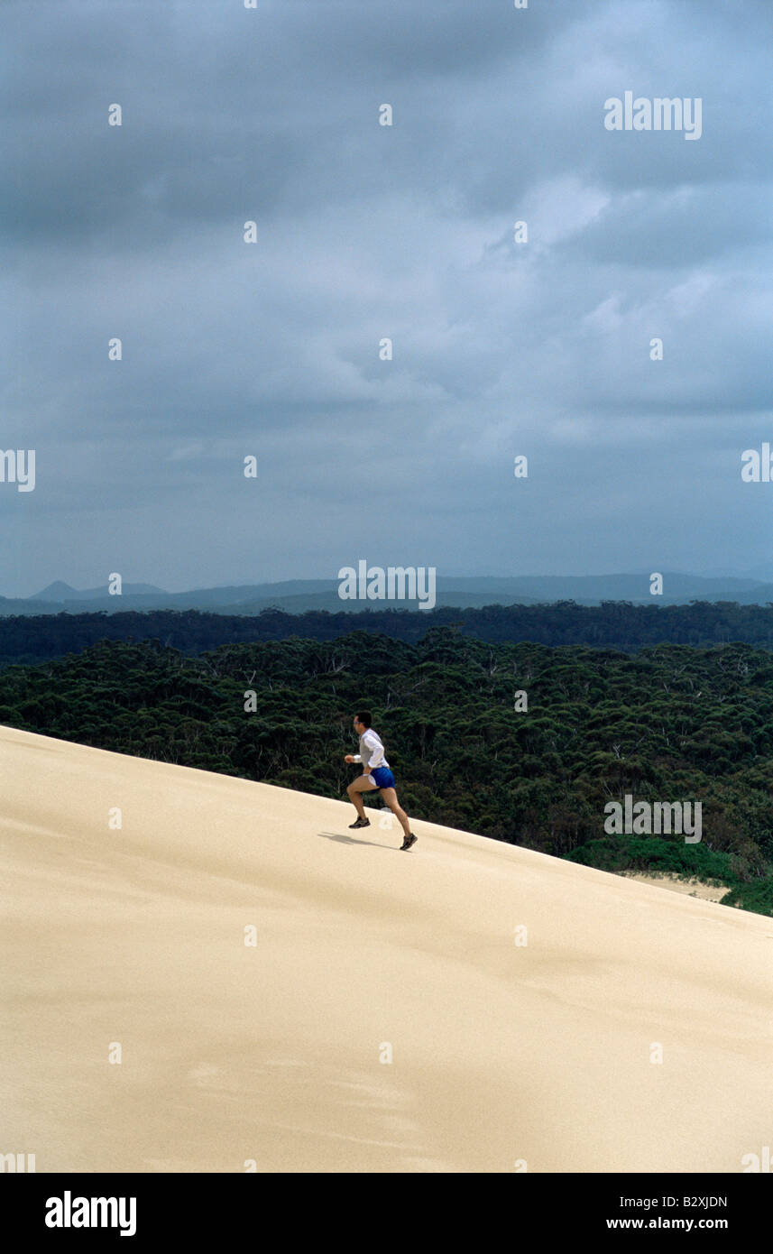 L'uomo all'aperto sulla collina di sabbia in esecuzione Foto Stock