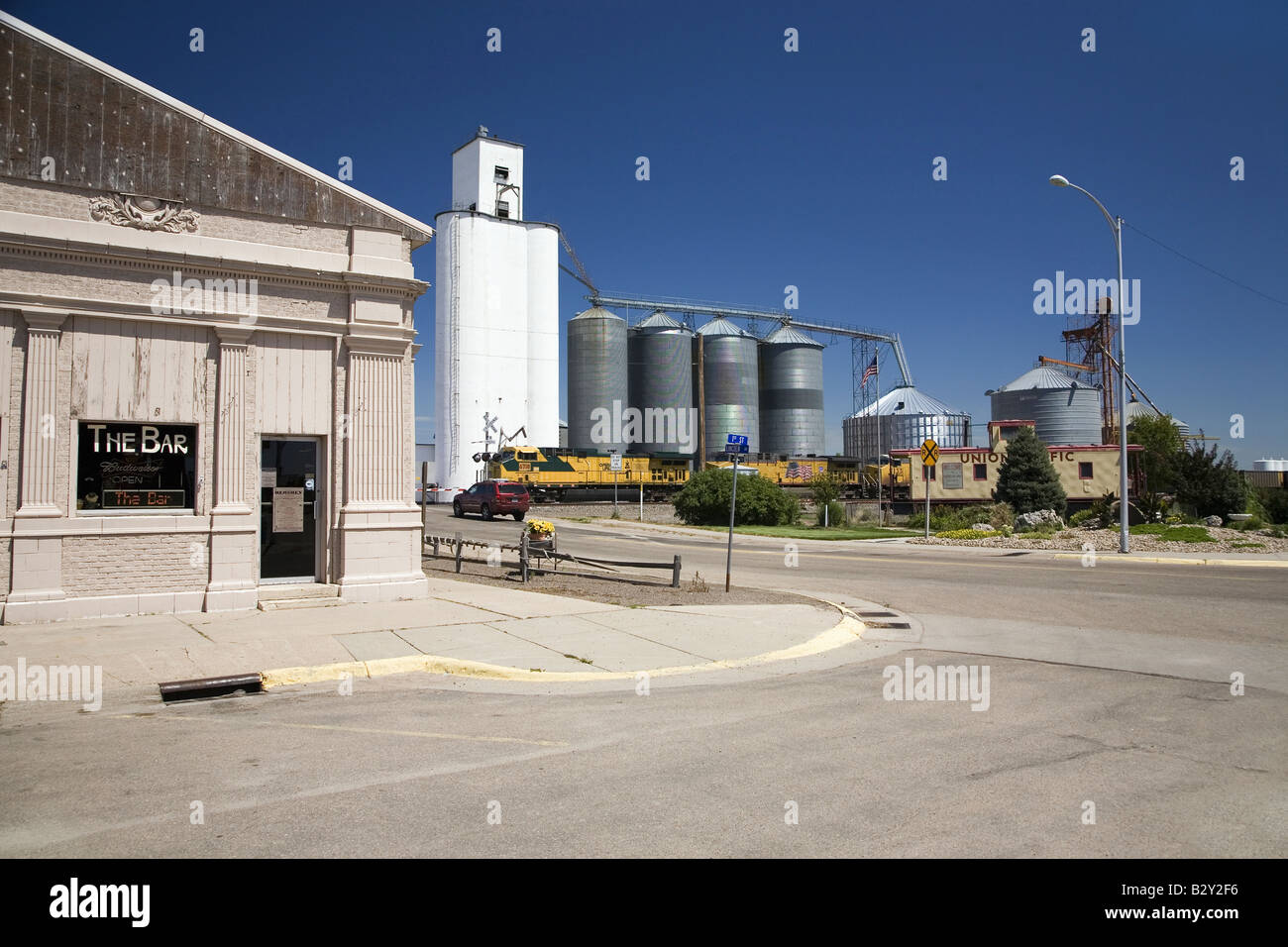 Un treno merci attraversando nei pressi di grano e un bar ad ovest di North Platte, Nebraska sul vecchio Lincoln Highway, US 30 Foto Stock
