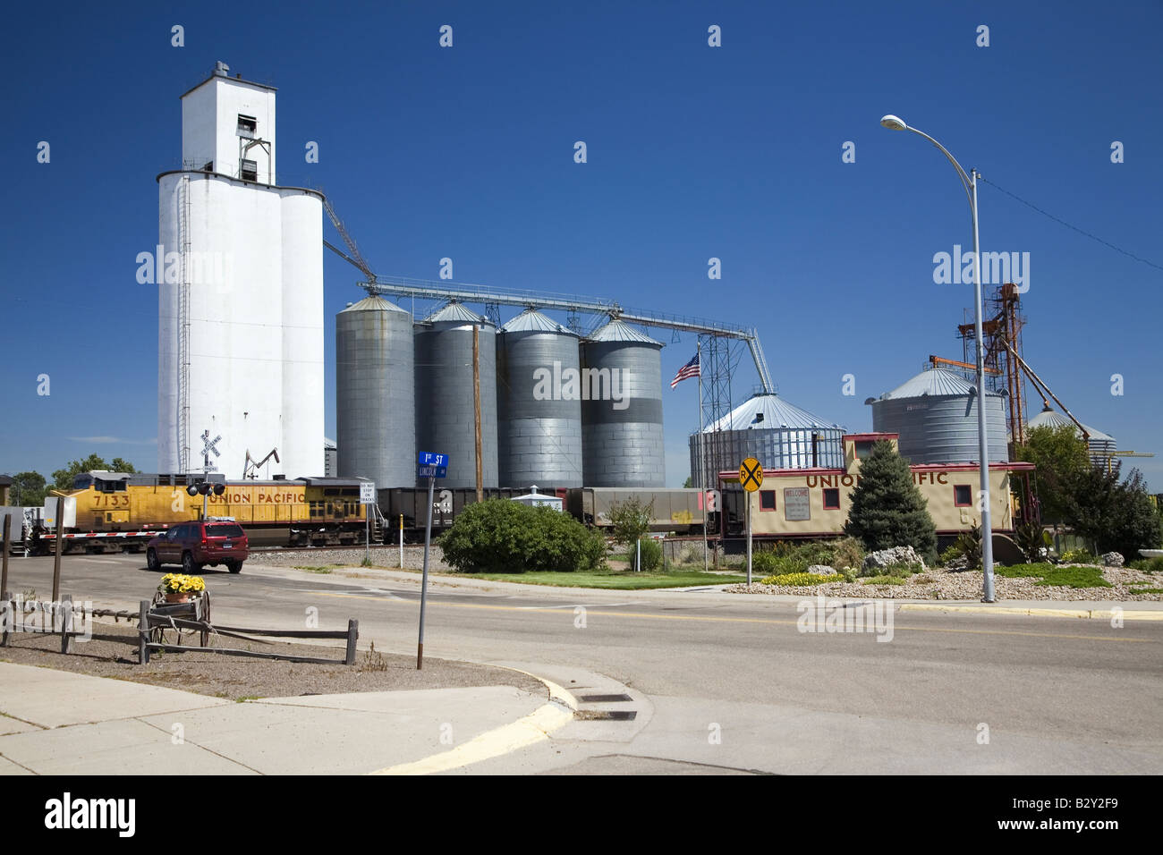 Un treno merci attraversando nei pressi di grano e un bar ad ovest di North Platte, Nebraska sul vecchio Lincoln Highway, US 31 Foto Stock