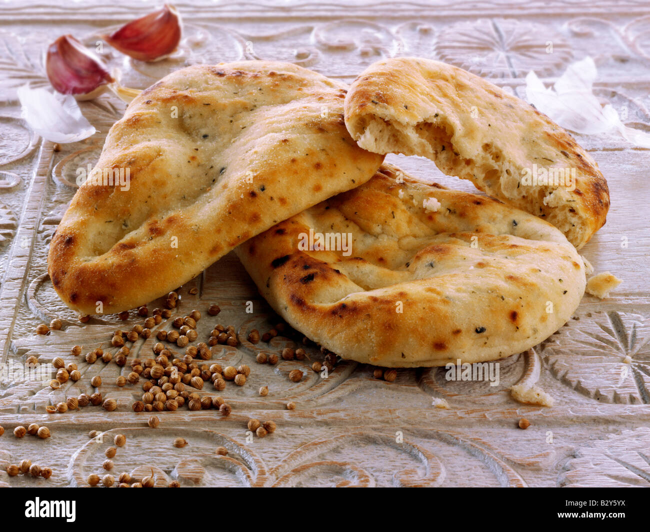 Aglio e coriandolo pane di Naan indiano servito pronto a mangiare su un tavolo Foto Stock