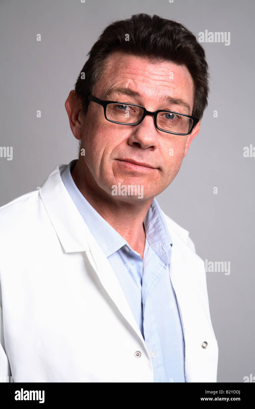 Maschio 40 qualcosa di medico sorridente che indossa un mantello bianco -bicchieri Foto Stock