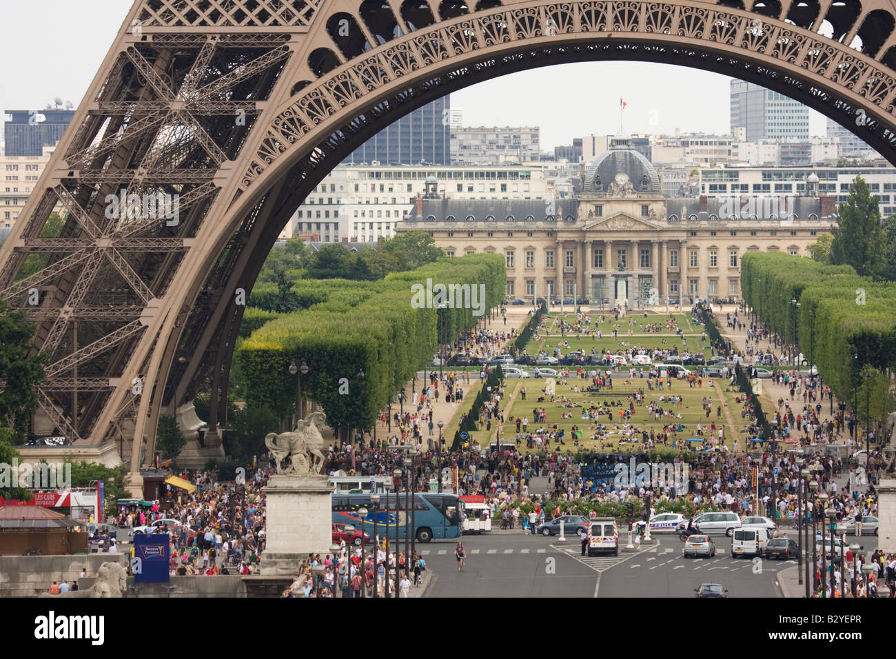Gruppi di persone all'ombra della Torre Eiffel e Parc du Champ de Mars in background Parigi Francia Foto Stock
