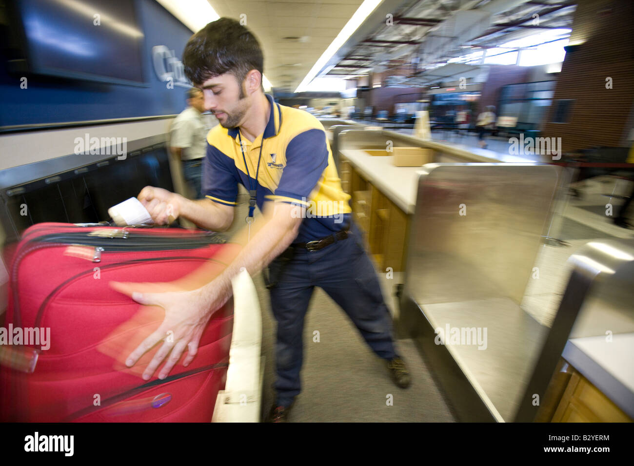 Un aeroporto lavoratore controlla il bagaglio al Springfield-Branson Aeroporto nazionale Foto Stock