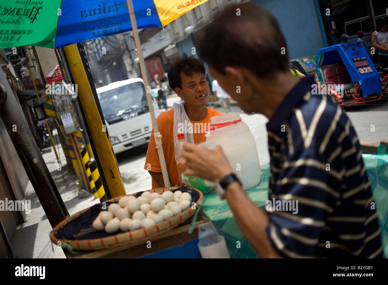 Un fornitore di prodotti alimentari la vendita balut sulla strada a Manila nelle Filippine. Foto Stock