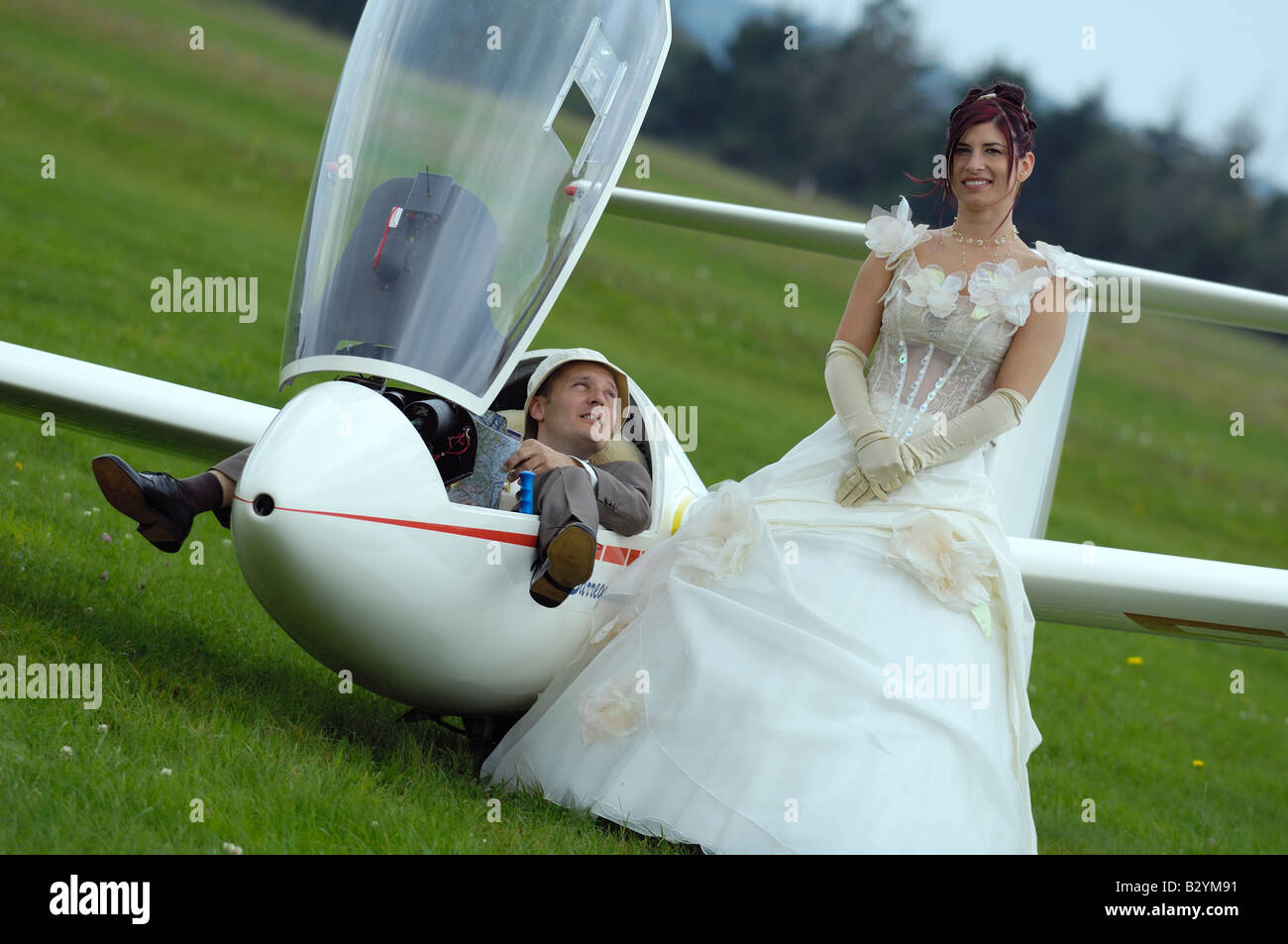 Coppia appena sposata in posa in prossimità di un piano glider, Francia Foto Stock