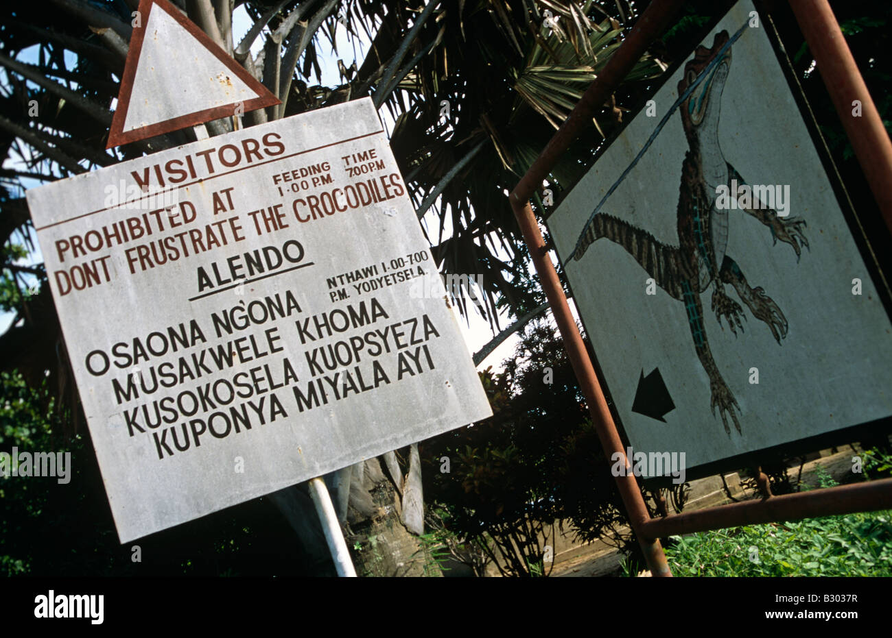 Cartello attenzione ai visitatori di essere una specie di coccodrilli in zoo. Il Malawi, Mozambico. Foto Stock