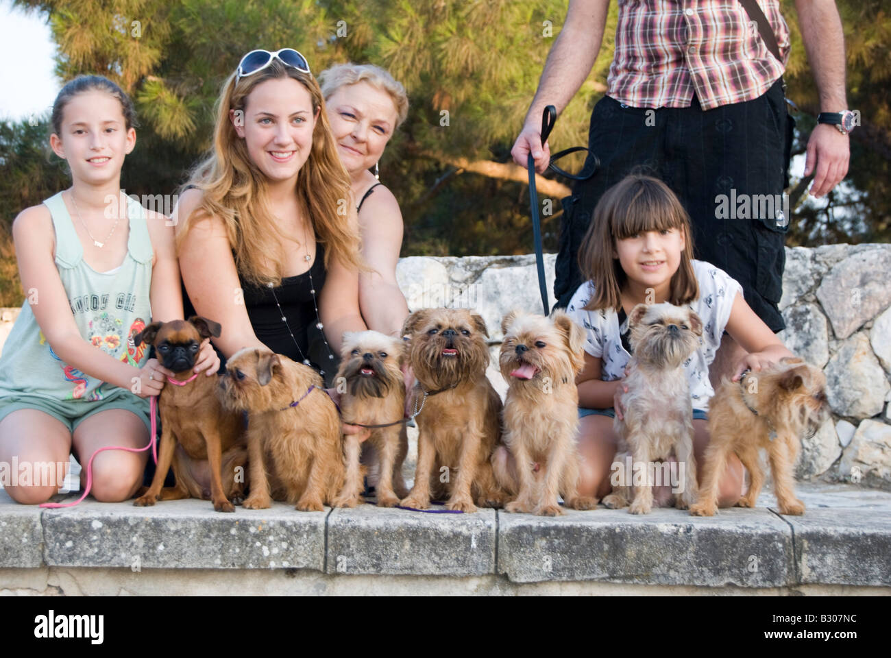 I proprietari che posano con loro Bruxelles Griffon dopo una mostra il cane Foto Stock
