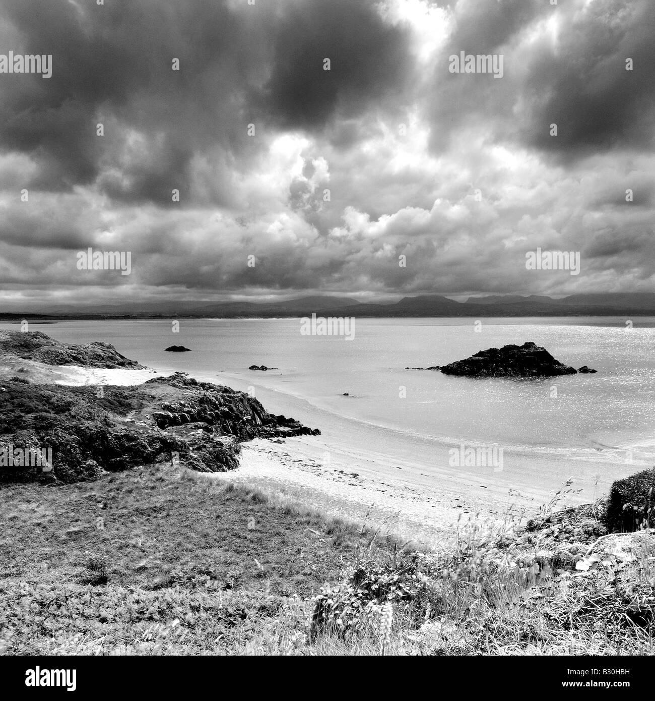 Porth Y Clochydd su Llanddwyn isola al largo della costa di Anglesey a Newborough Warren in bianco e nero Foto Stock