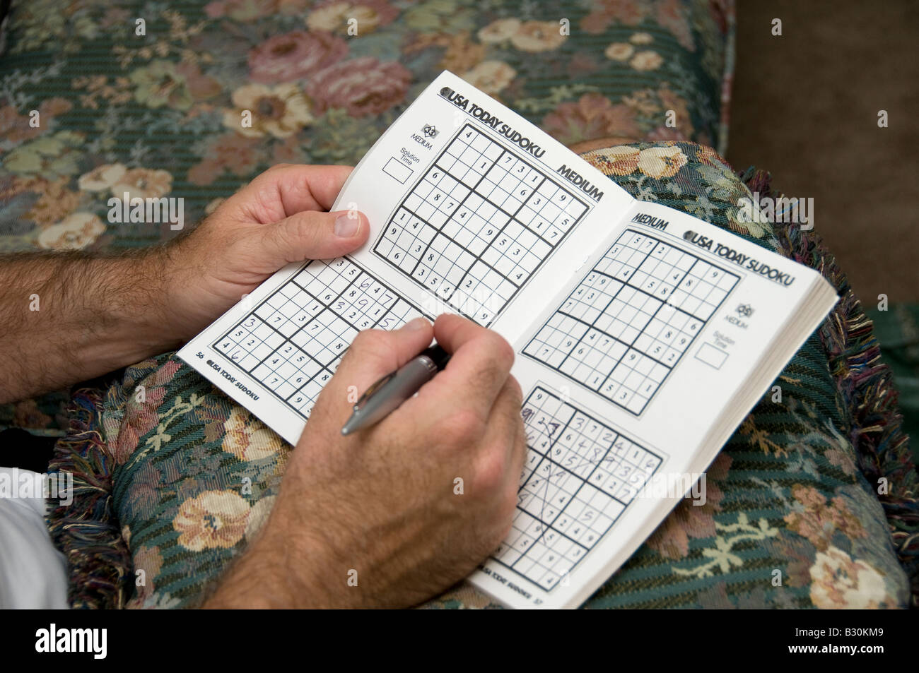 Un uomo adulto nel suo 40s funziona in un puzzle Sudoku. Hans soltanto.  Oklahoma, Stati Uniti d'America Foto stock - Alamy