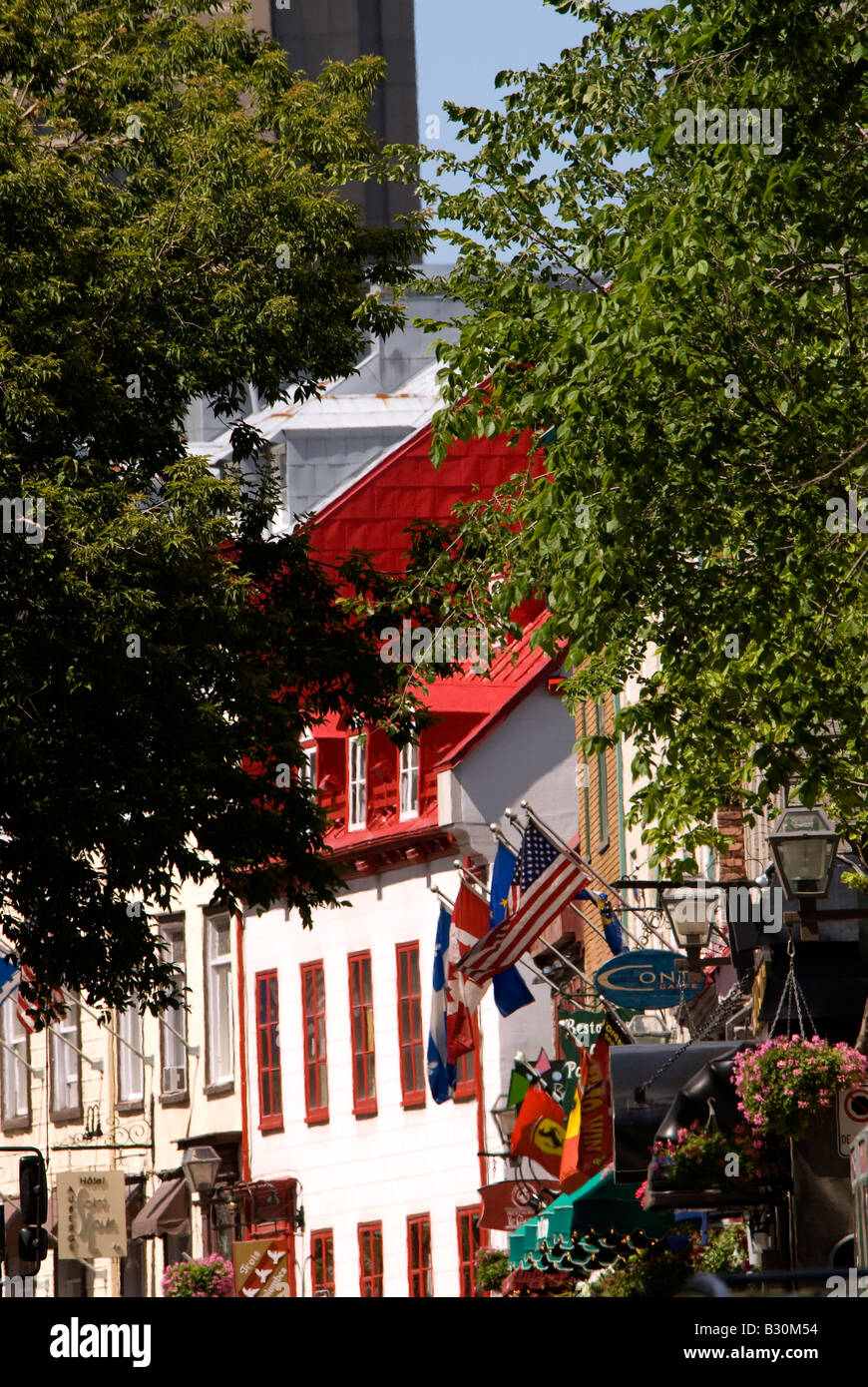 Scena di strada nella storica Vecchia Quebec city che mostra l'architettura francese, il tetto rosso, fiori e bandiere di aprire uno spazio di copia Foto Stock