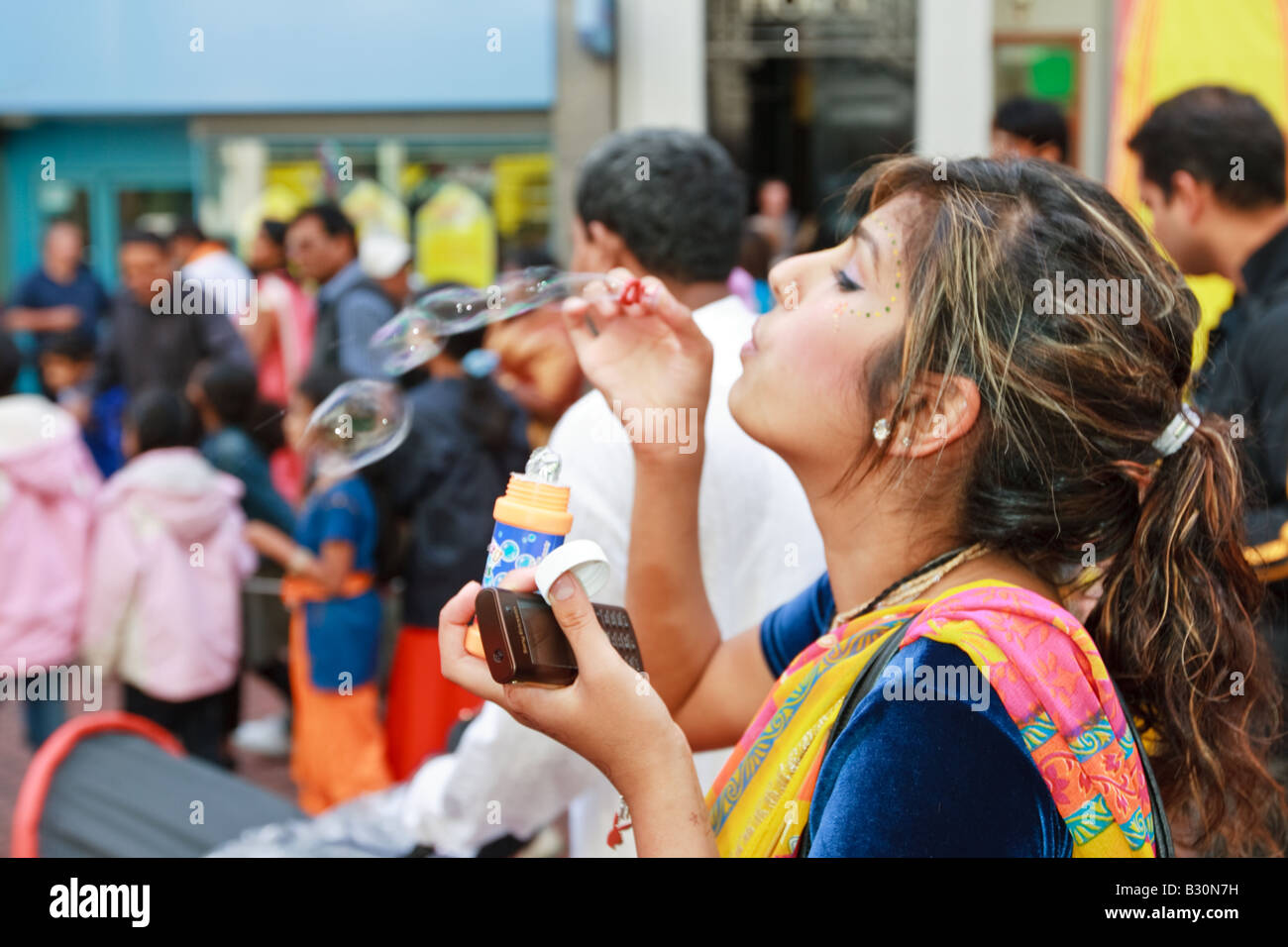 La donna a soffiare bolle al festival del Rathayatra celebrato a Birmingham Regno Unito Foto Stock