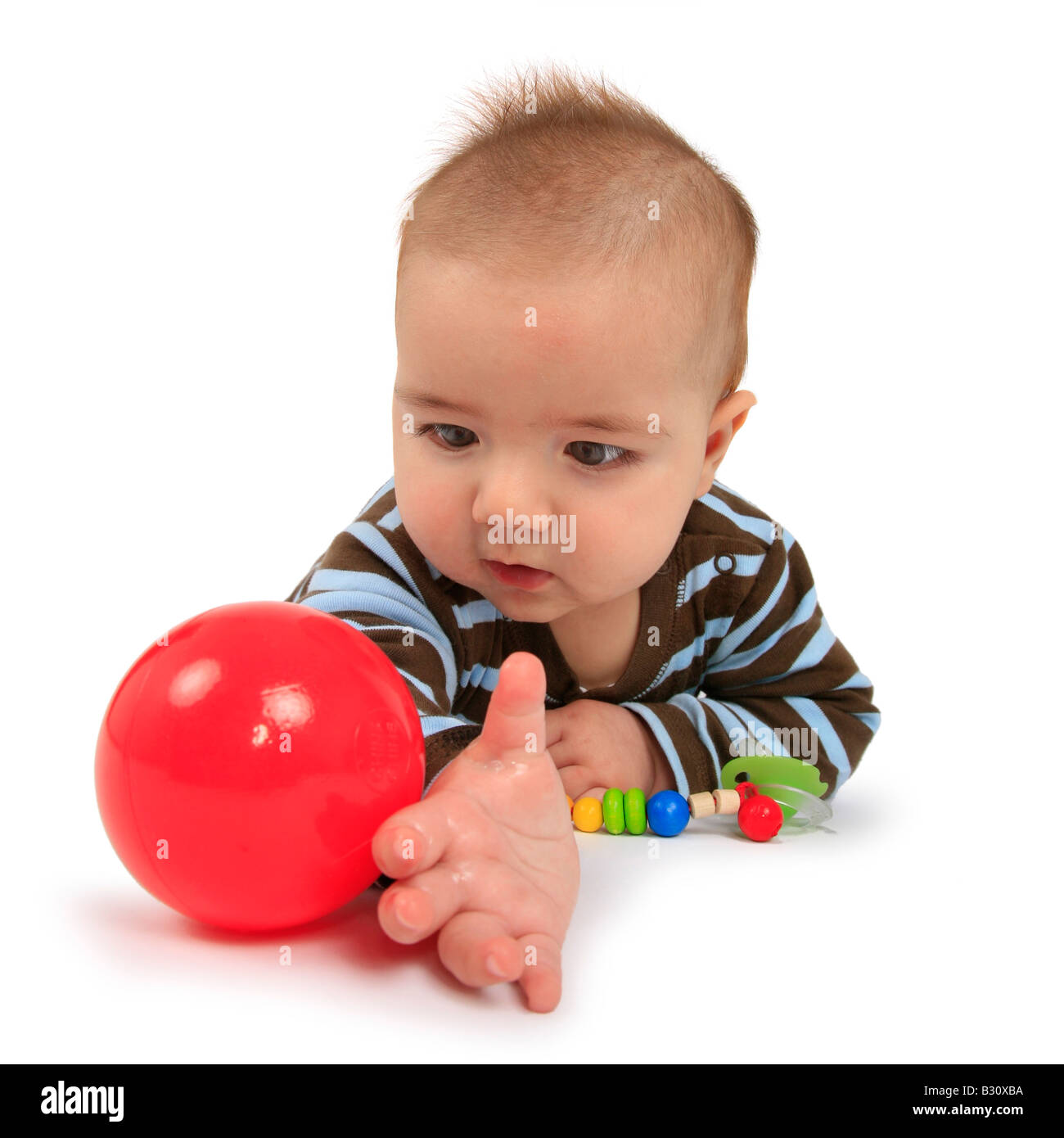 Baby il tentativo di afferrare una sfera Foto Stock