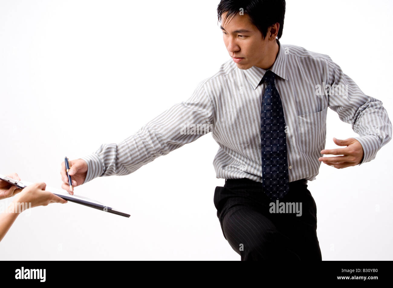 Un imprenditore cinese firma un contratto sulla clipboard mentre facendo un arte marziale Foto Stock
