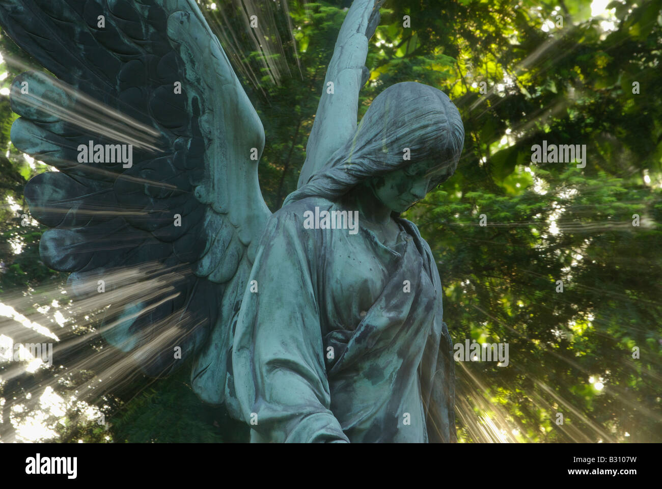 Angelo permanente di scultura circondato da una splendida aura di luce Foto Stock