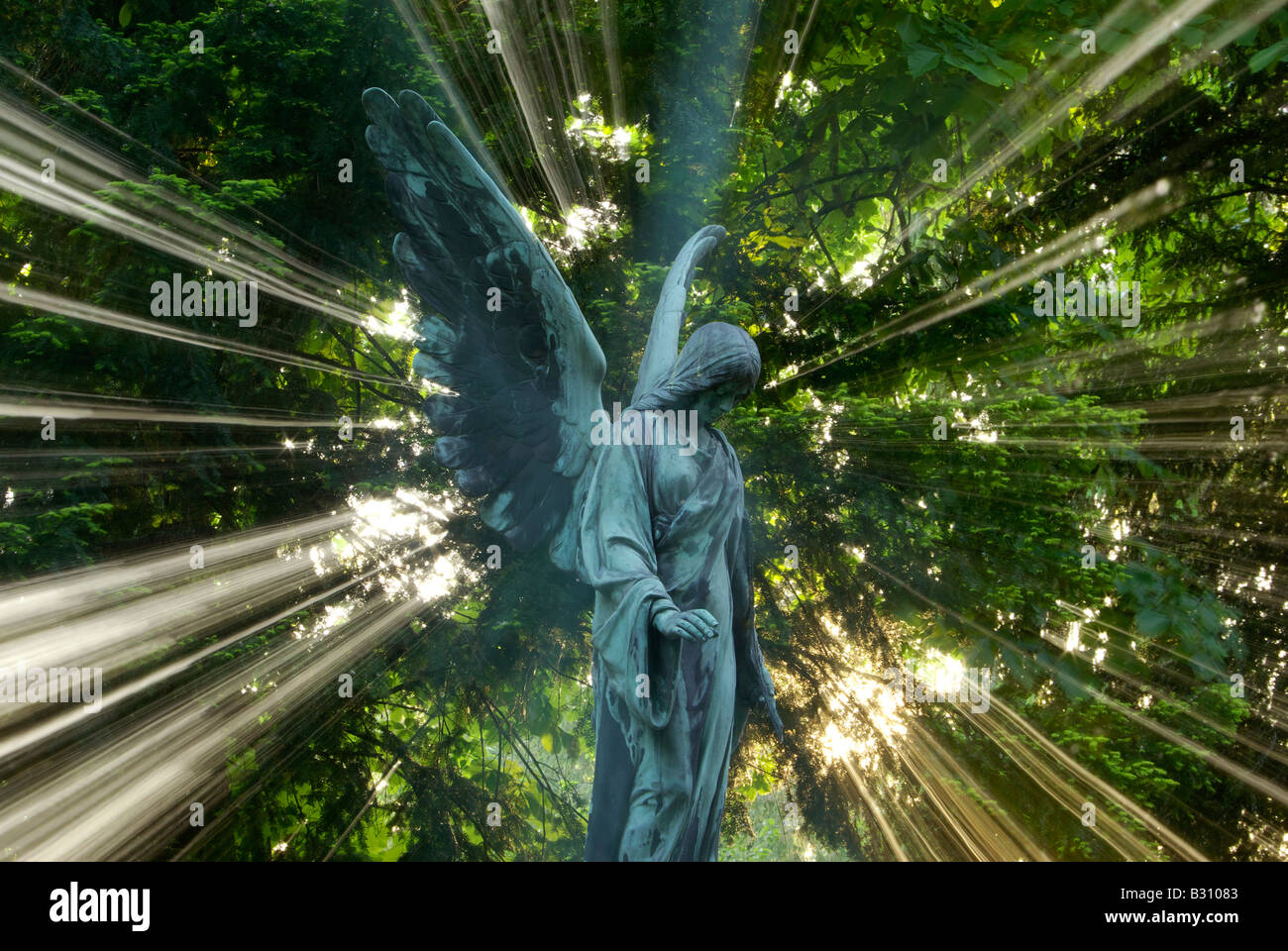 Angelo permanente di scultura circondato da una splendida aura di luce Foto Stock