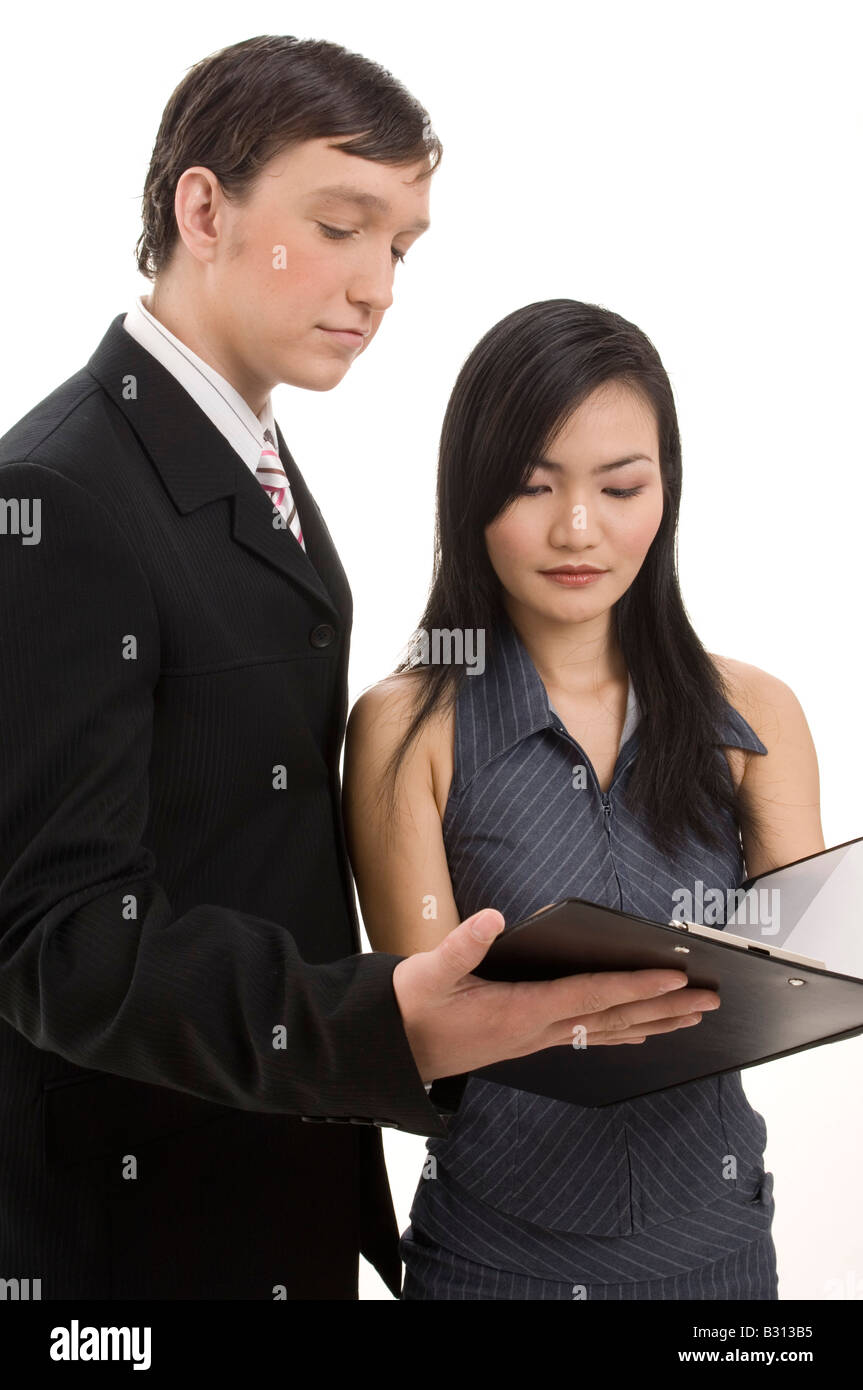 Un uomo di affari e donna di guardare al di sopra di un contratto in un blocco appunti. Isolato su sfondo bianco Foto Stock