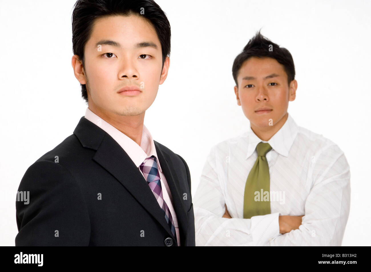 Due gravi-cercando asian giovane imprenditore (focus sull'uomo nella parte anteriore) Foto Stock