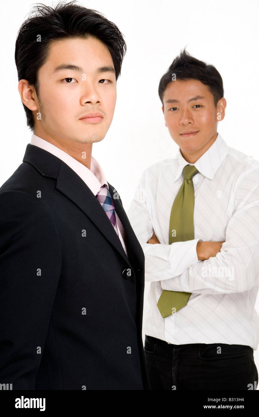 Due imprenditori asiatici su sfondo bianco (focus sull'uomo nella parte anteriore) Foto Stock