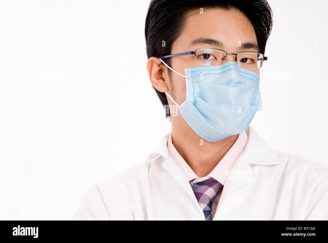 Un giovane uomo asiatico in faccia blu maschera e mantello bianco Foto Stock