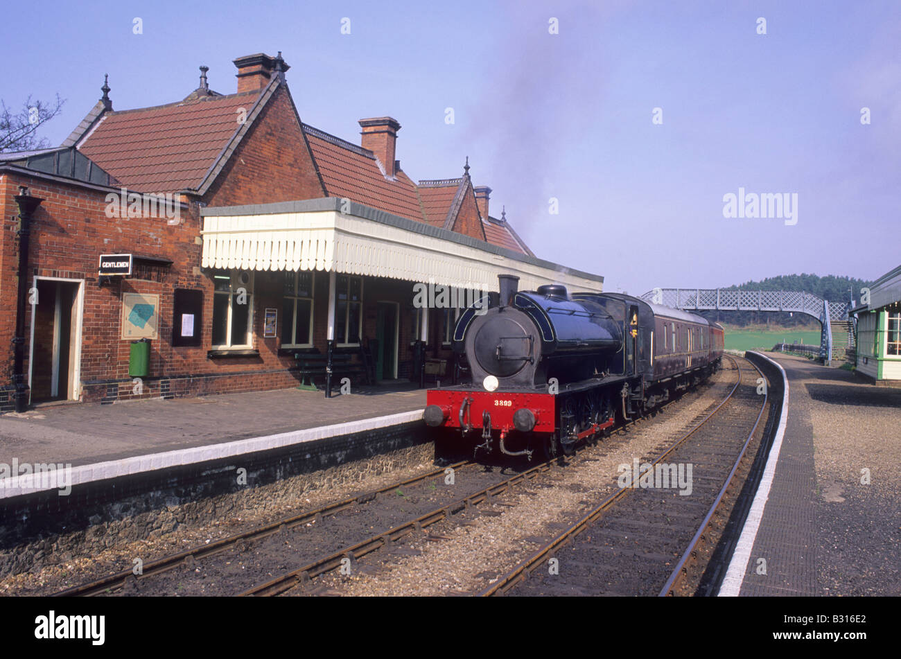 Stazione di Weybourne e treno a vapore, Norfolk Poppy Linea ferroviaria piattaforma motore carrelli tenda inglese sistema di trasporto Inghilterra Foto Stock