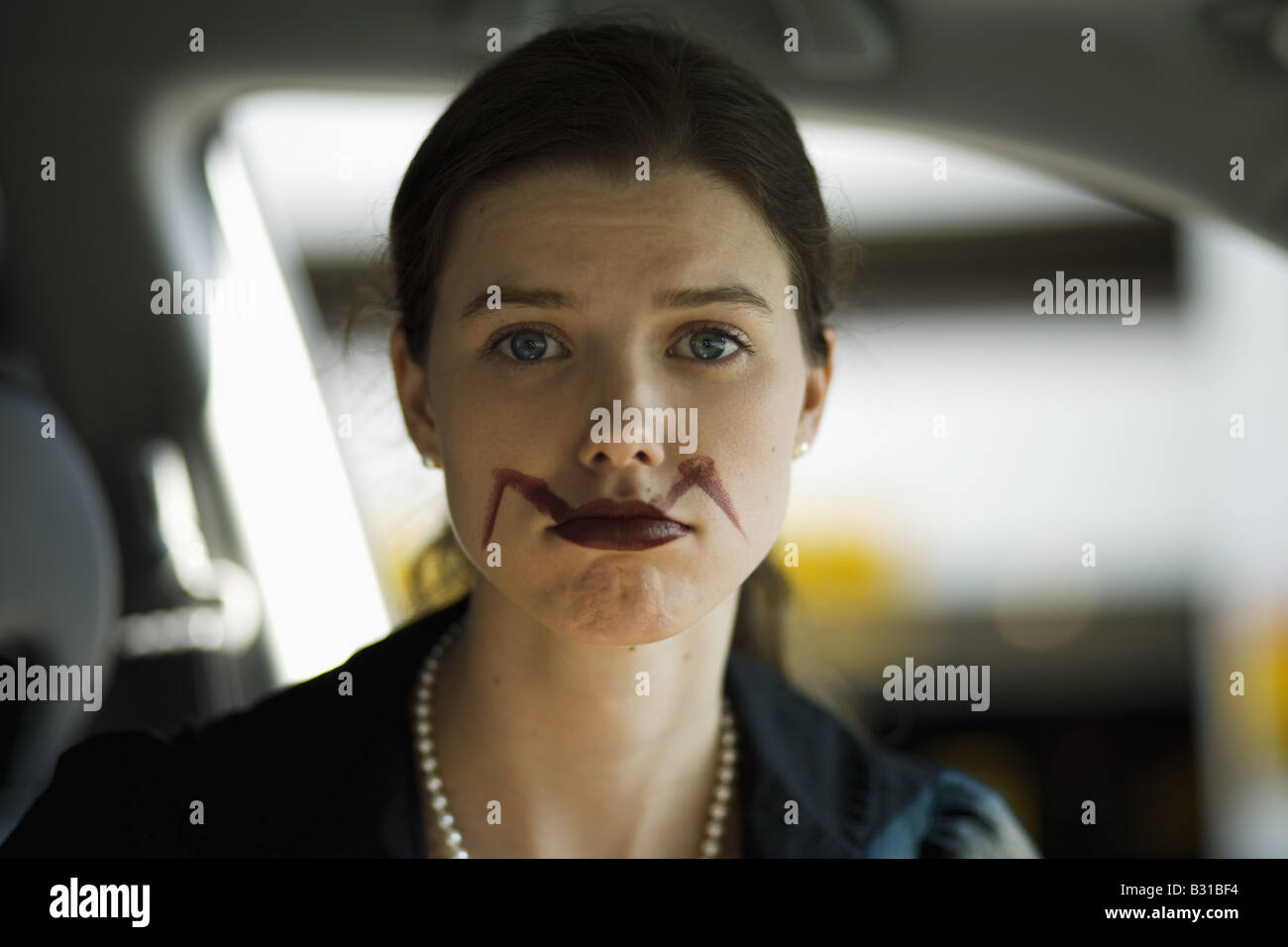 Giovane donna in auto con sbavature del rossetto Foto Stock