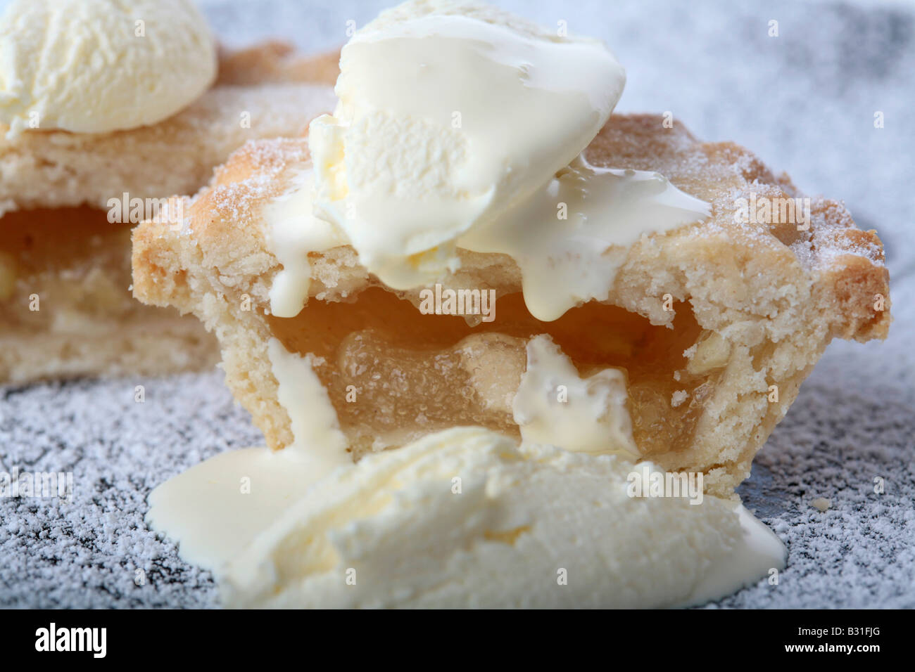 In prossimità di una piccola fetta di torta di mele su un zucchero placcato rivestito ricoperta di panna montata e fresca crema doppia Foto Stock