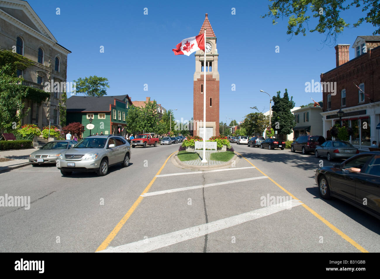Una bandiera canadese vola nella brezza di fronte alla torre dell orologio in downtown Niagara sul lago Ontario. Foto Stock
