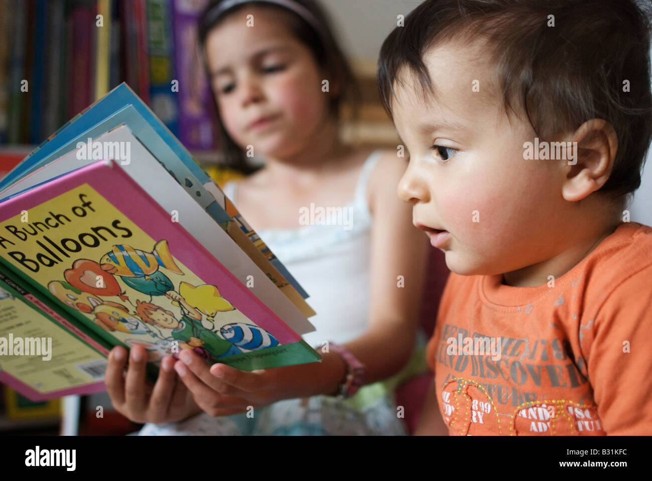 Vecchia sorella legge una storia per il suo fratellino Foto Stock