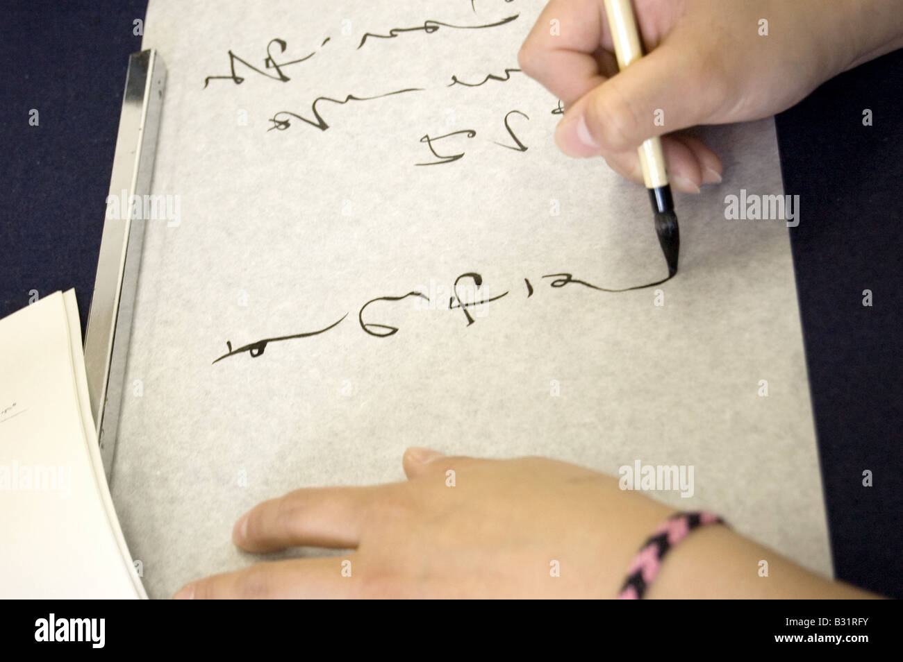 Advanced calligraphy studente pratica in un giapponese di alta scuola Foto Stock