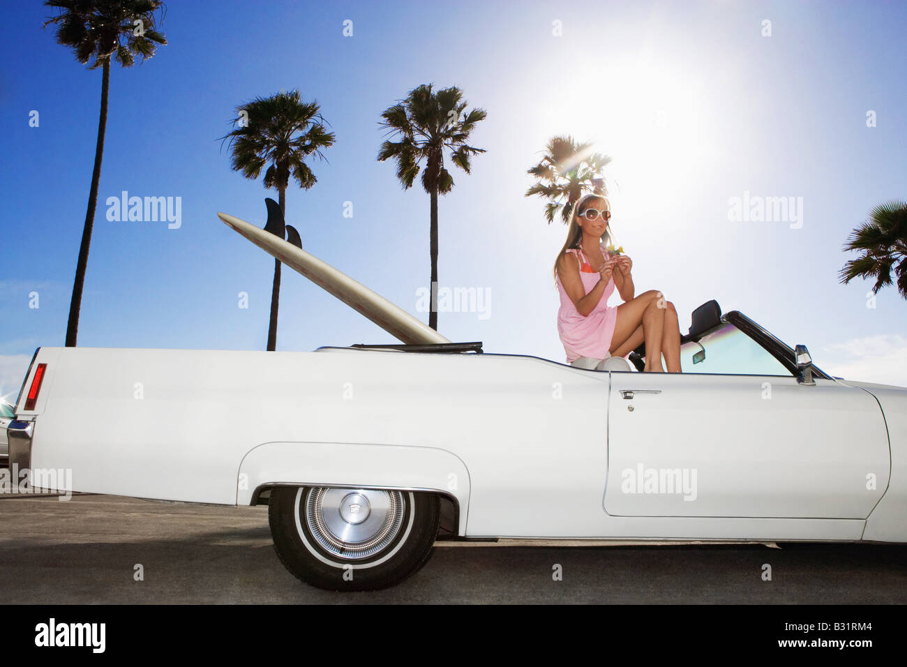 Donna seduta nel convertibile con tavola da surf 1969 Cadillac DeVille Cabrio Foto Stock